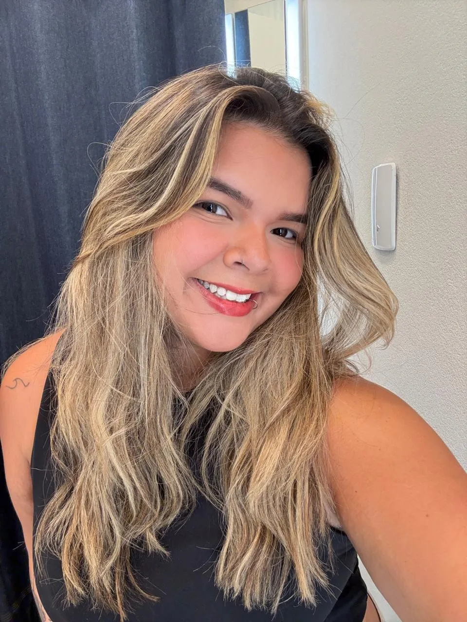 Maria Rejane sorrindo, de cabelos longos e blusa preta